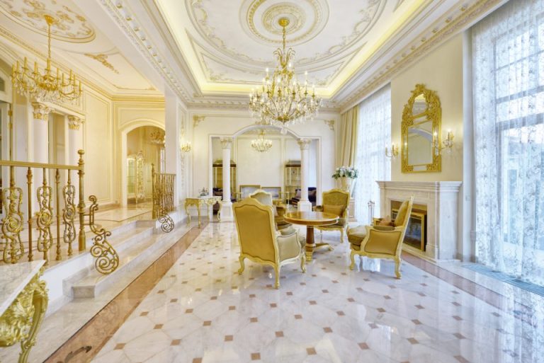 Ornate gilt salon with a chandelier, marble floor and gilded seating