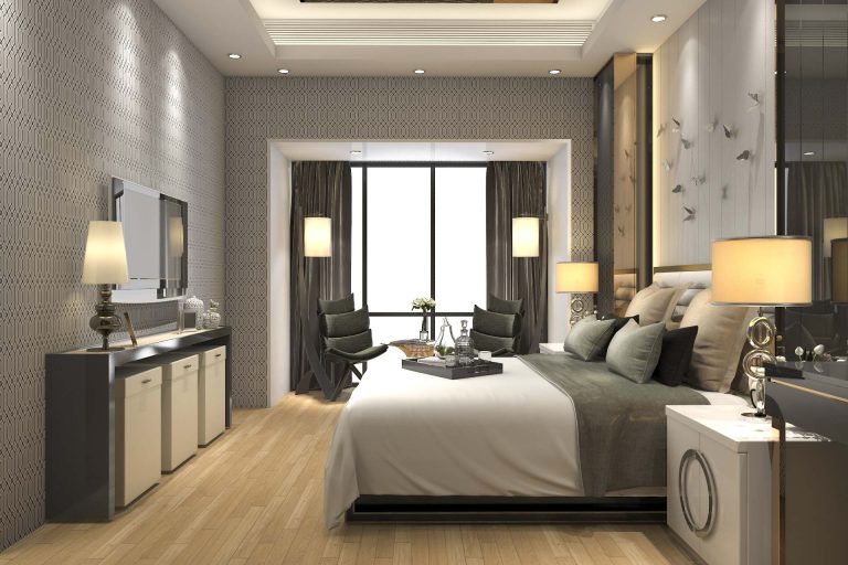 Contemporary hotel bedroom with upholstered headboard, bedside lighting and a writing desk