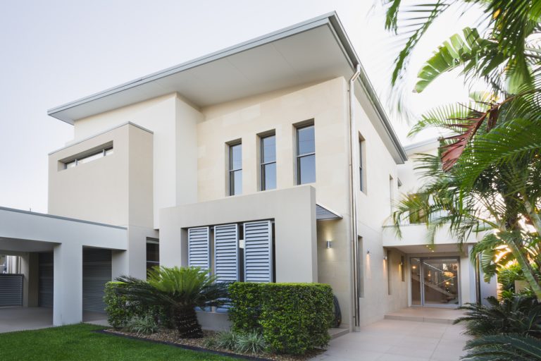 Exterior of a modern white rendered commercial building with mature planting