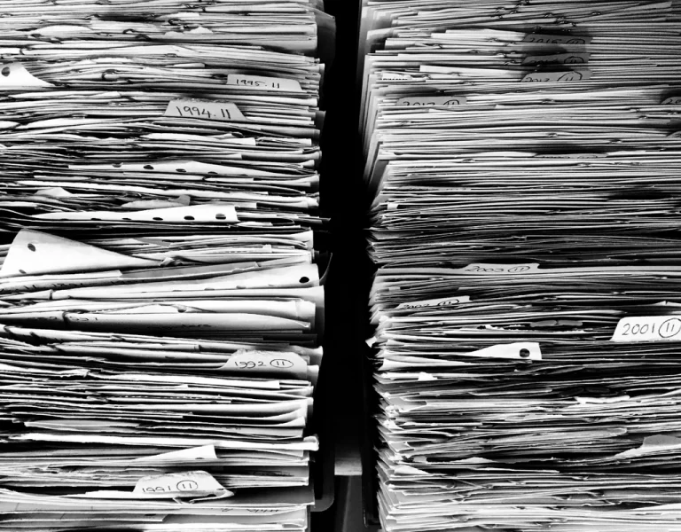 Tall stacks of bundled paper records and documents seen from the side